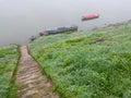 Foggy and gloomy autumn scene of boats moored along riverbank. Royalty Free Stock Photo