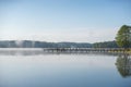 Foggy lake pier in early morning Royalty Free Stock Photo