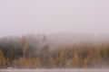 Foggy lake scape and vibrant autumn colors in trees Royalty Free Stock Photo