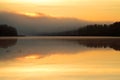 Foggy lake shore in the morning sun rise Royalty Free Stock Photo