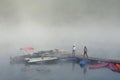 Foggy landscape with calm lake and pier.Mist over water. Beautiful freedom moment and peaceful atmosphere in nature Royalty Free Stock Photo