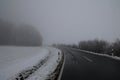 Foggy landscape of dangerous stretch of road during a winter