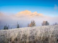 Foggy landscape in the morning. Mountain peak. Sunbeams in a valley. Field in a mountain valley at dawn. Royalty Free Stock Photo