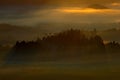 Foggy landscape with sunrise. Cold misty foggy morning with sunrise in a fall valley of Bohemian Switzerland park. Hills with fog