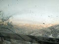 Foggy mist moisture on the car glass window with water drops with a view of nature and sunny cold winter day during holiday season Royalty Free Stock Photo
