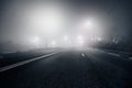 Foggy misty night road illuminated by street lights Royalty Free Stock Photo