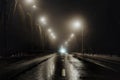 Foggy misty night road illuminated by street lights Royalty Free Stock Photo