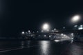 Foggy misty night road and overhead pedestrian bridge illuminated by street lights