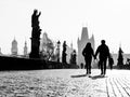 Foggy morning on Charles Bridge, Prague, Czech Republic. Sunrise with silhouettes of walking people, statues and Old Royalty Free Stock Photo