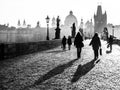 Foggy morning on Charles Bridge, Prague, Czech Republic. Sunrise with silhouettes of walking people, statues and Old Royalty Free Stock Photo