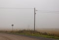 A foggy morning in the countryside in Finland. An old telephone pole with an air wire. Royalty Free Stock Photo