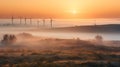 A foggy morning in a field with multiple windmills visible in the distance Royalty Free Stock Photo