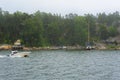 Foggy morning at Helsinki archipelago. Mist landscape with fast motorboat