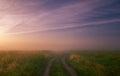 Foggy morning meadow.Summer landscape with green grass, road and clouds Royalty Free Stock Photo