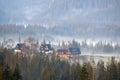 Foggy morning mist over mountain valley with wooden rural farm house buildings Royalty Free Stock Photo