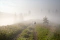 Foggy morning in the mountains, a lonely tourist watching the sunrise. The Carpathians