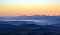 Foggy morning in the mountains with silhouettes of hills. Serenity sunrise with soft sunlight and layers of haze Royalty Free Stock Photo