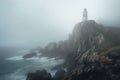 foggy morning surrounding an isolated lighthouse on a cliff