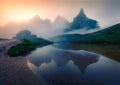 Foggy morning view of Baita Segantini mountain refuge with Cimon della Pala peak. Fantastic summer sunrise in Dolomiti Alps, Rolle