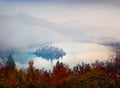 Foggy morning view of church of Assumption of Maria. Amazing outdoor scene of Bled lake. Stunning autumn landscape of Julian Alps, Royalty Free Stock Photo