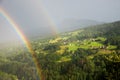 foggy mountain landscape with double rainbow and view to Conters village, prattigau switzerland