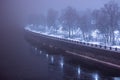 Foggy night landscape in a park with a waterfront, square by the river