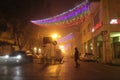 Foggy night scene with solitary man and christmas light decorations