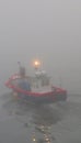 Brave fisherman heading out to sea in the cold light of a foggy dawn from Mevagissey harbour on the south Cornish coast England Royalty Free Stock Photo