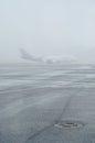 Foggy overlay on the airport runway. Bad weather overcast. Iron sewer hatch and asphalt on runway are very icy