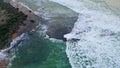 Foggy sea covering beach drone view. Rippling waves washing volcanic pebbles