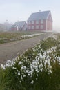 Foggy summer morning in Greenland. The picturesque Ilulissat village on the Greenland Sea shore. Old wooden house in Ilulissat Royalty Free Stock Photo