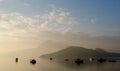 Foggy sunrise landscape photo with boat, mountain