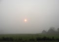 Foggy orange sunrise over country hillside homestead Royalty Free Stock Photo