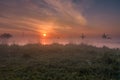 Foggy sunrise with the siloute of the windmills Royalty Free Stock Photo