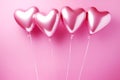Foil air balloons on pastel pink background. Pink heart shaped helium balloons on pink background. Minimal love concept. Valentine