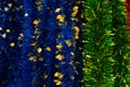 Foil blue green tinsel with golden leaves, backdrop close-up background. Stripes glittering garland polythene foil, Christmas Royalty Free Stock Photo