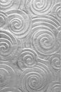 Foil metal grey background with pattern of spiral curls