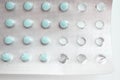 Foil packet of little round pills on white. Close-up blue medicine tablets packed in blister. Macro drugs in using