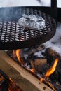 Foil wrapped food on a grill over the campfire in winter