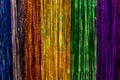 Foiled shiny rain tinsel yellow green blue, backdrop close-up background. Stripes glitter garland rainbow rainbow decoration for