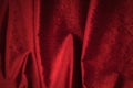 Fold soft waved red velour fabric textured background.