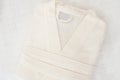 Folded bathrobe on bed in room. White robe Royalty Free Stock Photo