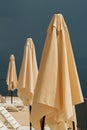 Folded beach parasol umbrellas at seaside with stormy clouds in background