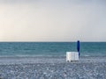 Folded beach umbrella and sunbeds. End of beach season. Not bathing time. High wave Royalty Free Stock Photo