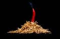 Folded on a black background in the form of a bonfire matches underscore the pungency of the red hot pepper escaping from a fire