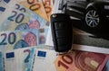 Folded black car key and cut out car catalog on euro money banknotes Royalty Free Stock Photo