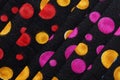 Folded fabric with red, blue, pink, gold and green dots / circles