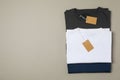 Folded blank t-shirts with tags on gray background Royalty Free Stock Photo