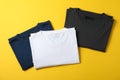 Folded blank t-shirts on yellow background Royalty Free Stock Photo