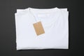 Folded blank white t-shirt with tag on black background Royalty Free Stock Photo